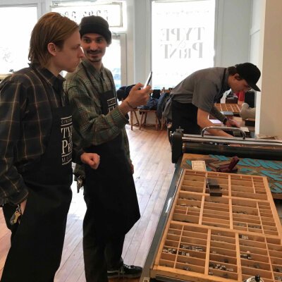 Three students from Cincinnati Art Academy setting their poetry in letter press type.