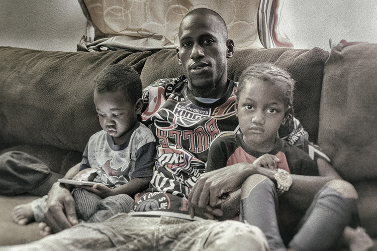 Alhassane Moussa with his two kids at their home in Lockland.