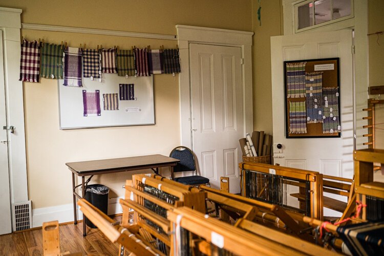Colorful weaving projects and samples on display in one of the workrooms.