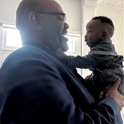 Mayor Washington with infant son of La Vela Venue owner Estella Nchumuluh at the venue's ribbon cutting event.