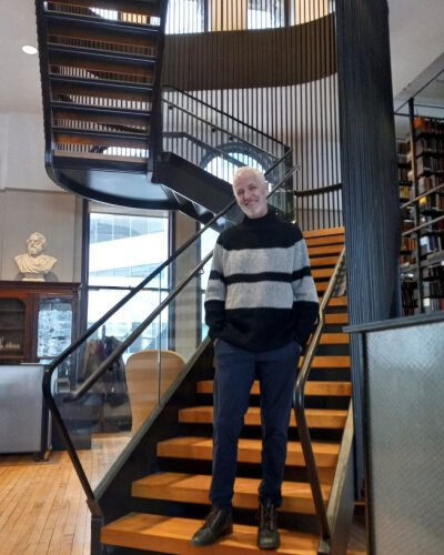 Mercantile Library executive director, John Faherty, stands at the foot of the new staircase built and installed at the Mercantile Library downtown.