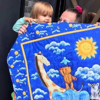A child in Ukraine receives a blanket sent by Cincy4Ukraine. 